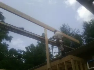Carpenter setting a ridge beam over a new addition frame — Ice Dam Removal by Roofing Brothers in Stamping Ground