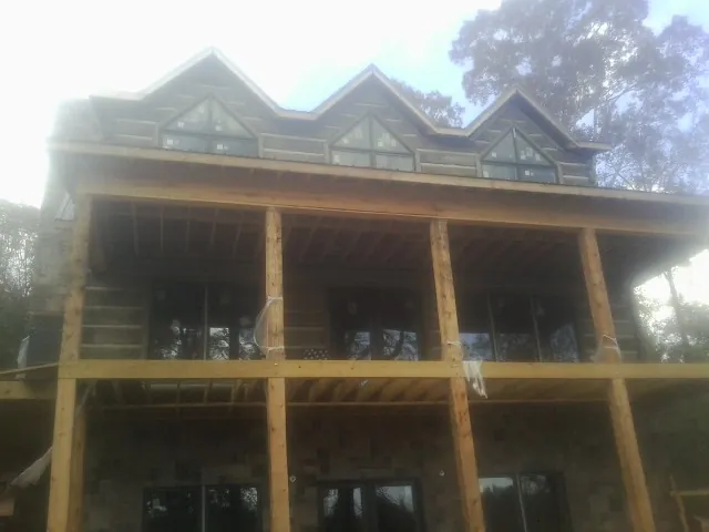 Dormers and porch framing on a large log home under construction — Roof Coating work by our crew in Stamping Ground