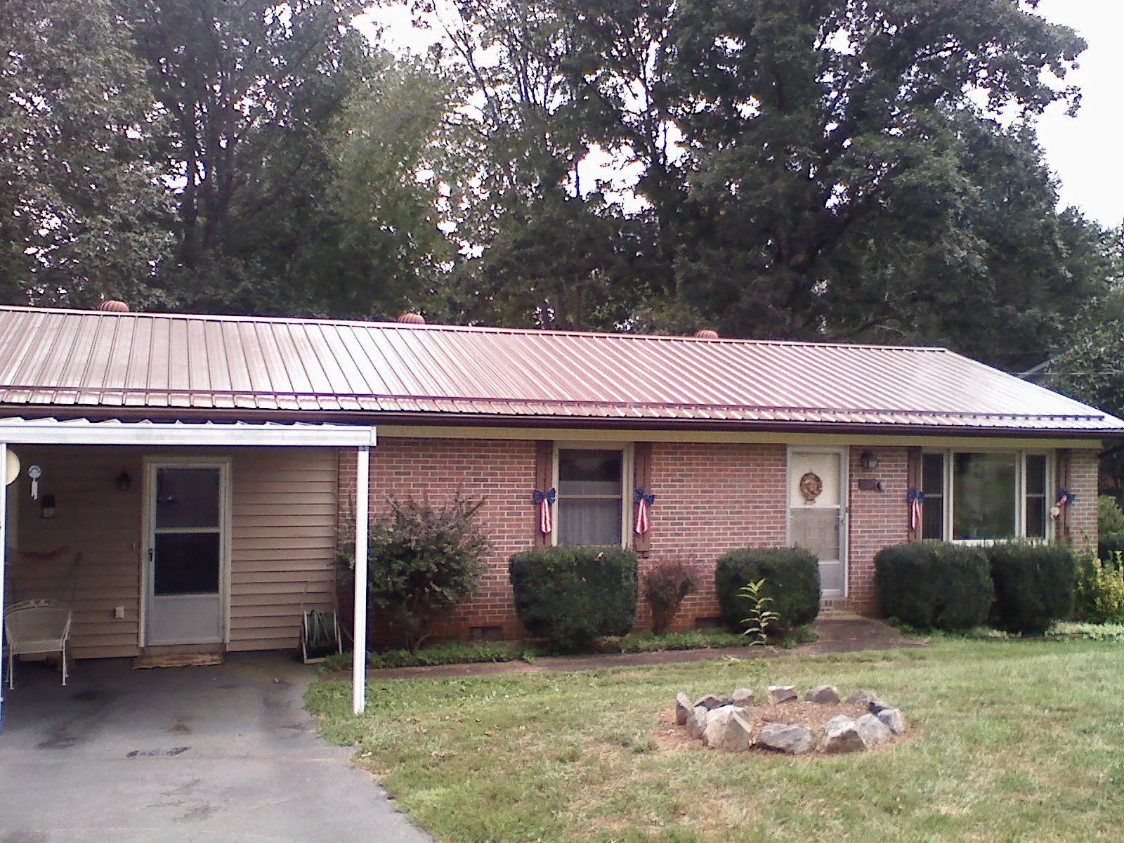 Bronze metal roof and carport on a brick ranch home — Roof Repair work by our crew in Stamping Ground
