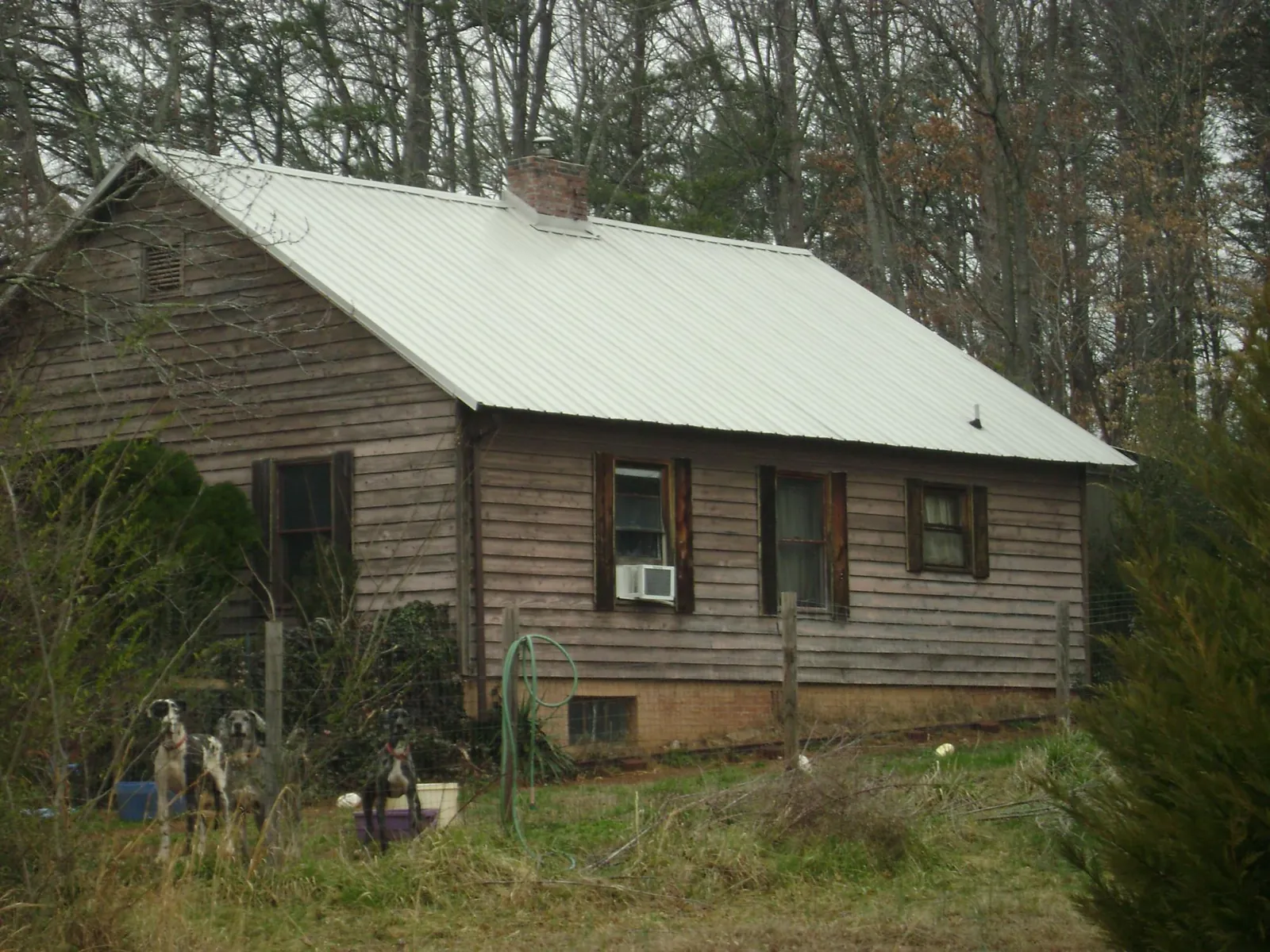 White metal roof on an old wood sided farmhouse, from a Metal Roof Installation job in Stamping Ground